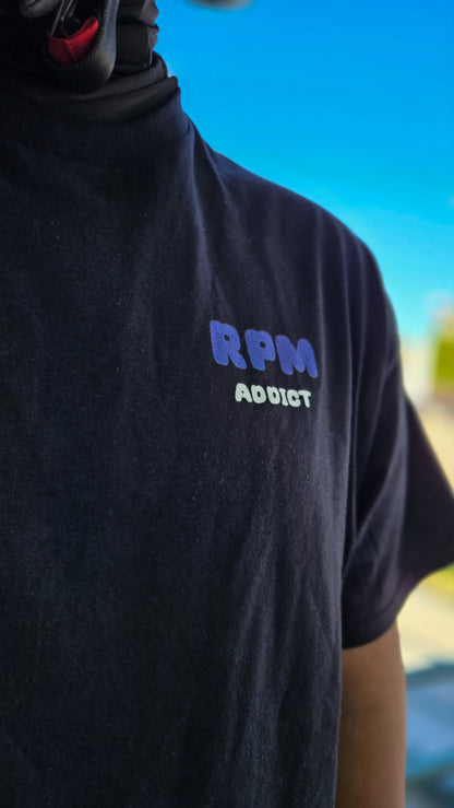 Person wearing a black t-shirt with 'RPM Addict' text against a blue sky.